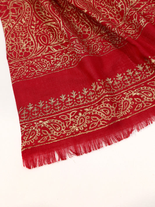 Red fabric with gold embroidery on a white background