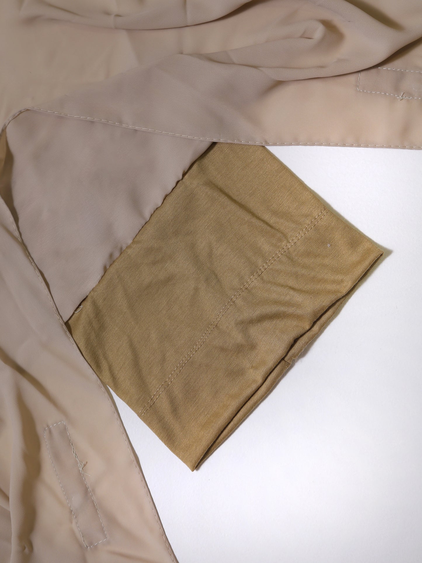 Close-up of beige fabric with a white background