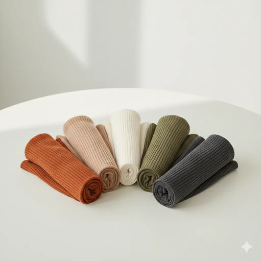 Set of folded ribbed knit socks in various colors on a white surface.