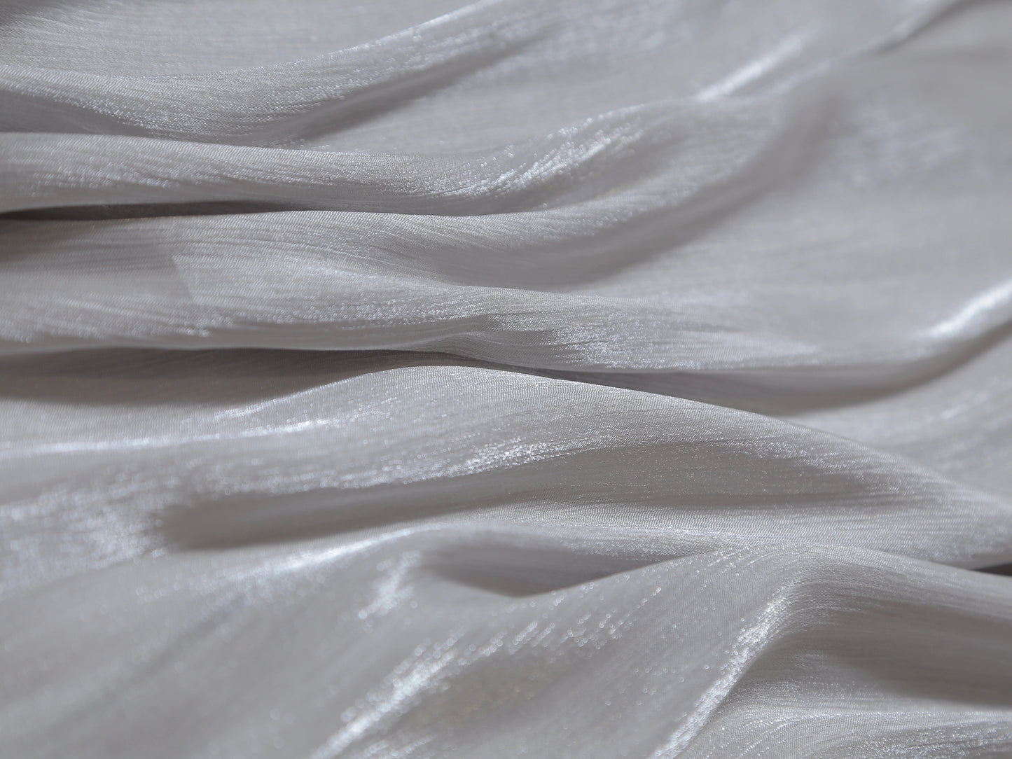 Close-up of silver metallic fabric with a textured surface