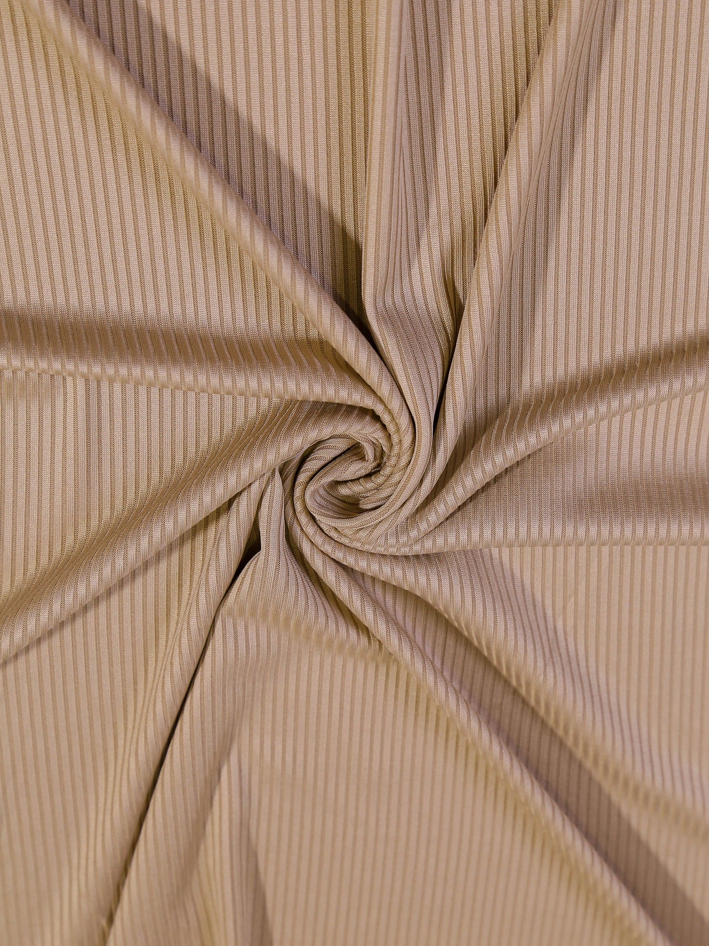 Close-up of beige ribbed fabric with a swirl pattern