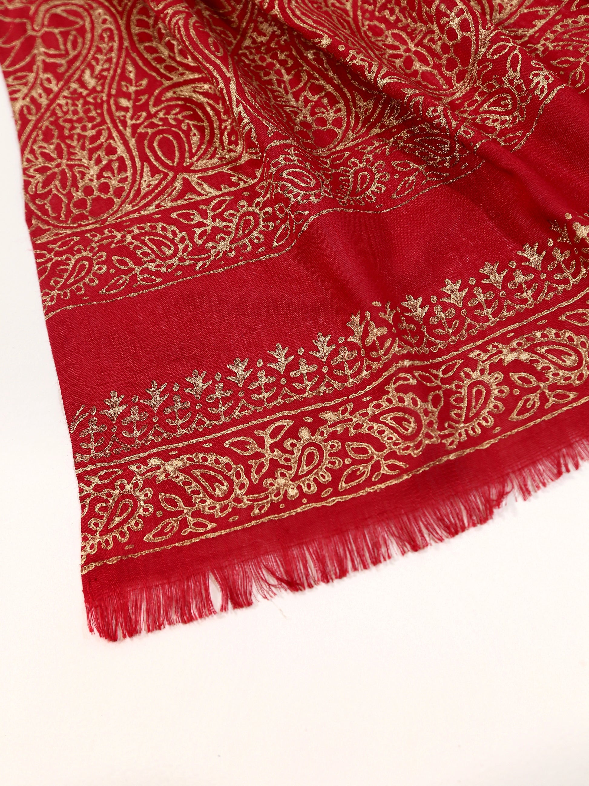 Red fabric with gold embroidery on a white background