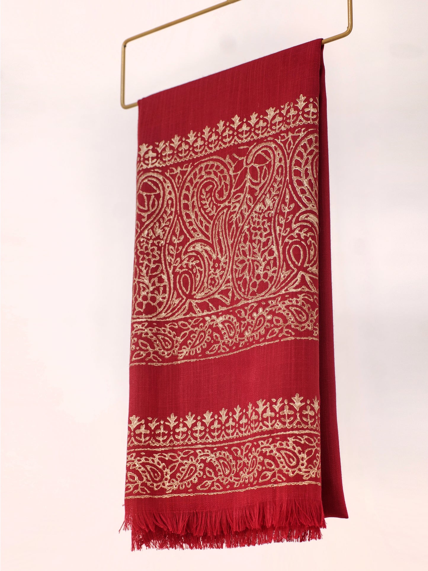 Red scarf with white intricate patterns on a white background