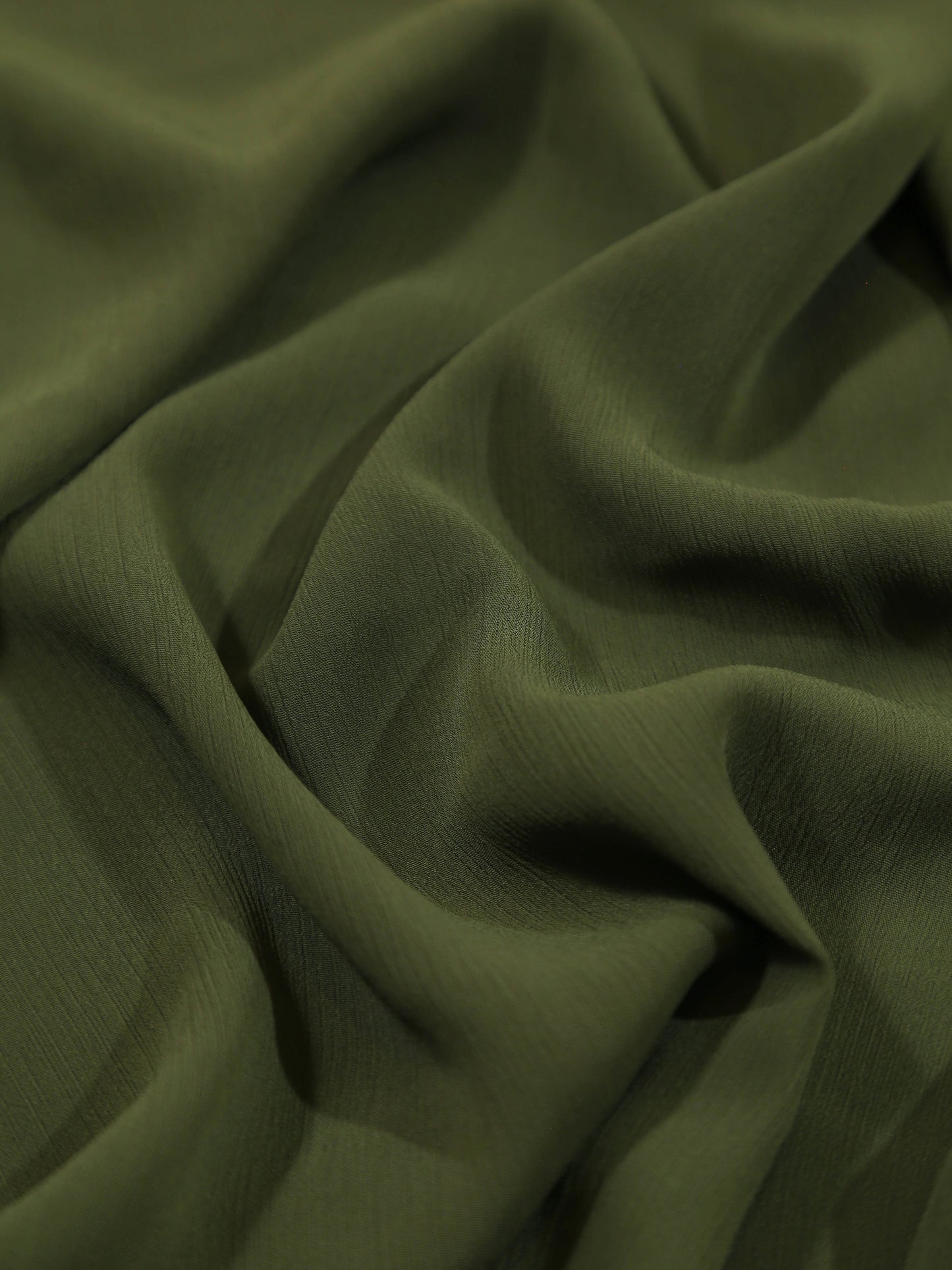 Close-up of olive green fabric with folds