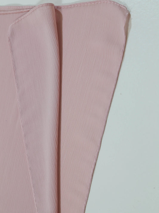 Soft textured fabric swatch in pale pink showing folds and fine crinkle details, Crinkle Georgette - Powder Pink.
