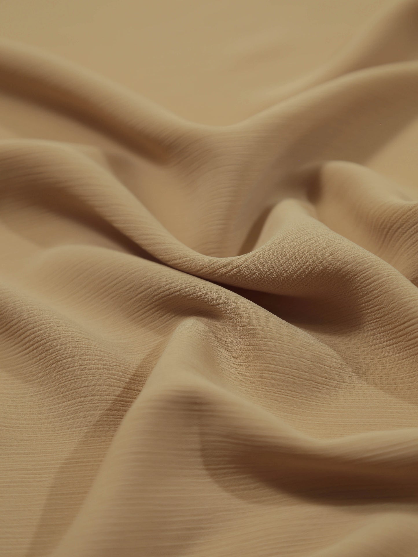 Close-up of soft crinkled fabric in a warm mocha shade, showcasing texture of Crinkle Georgette - Mocha
