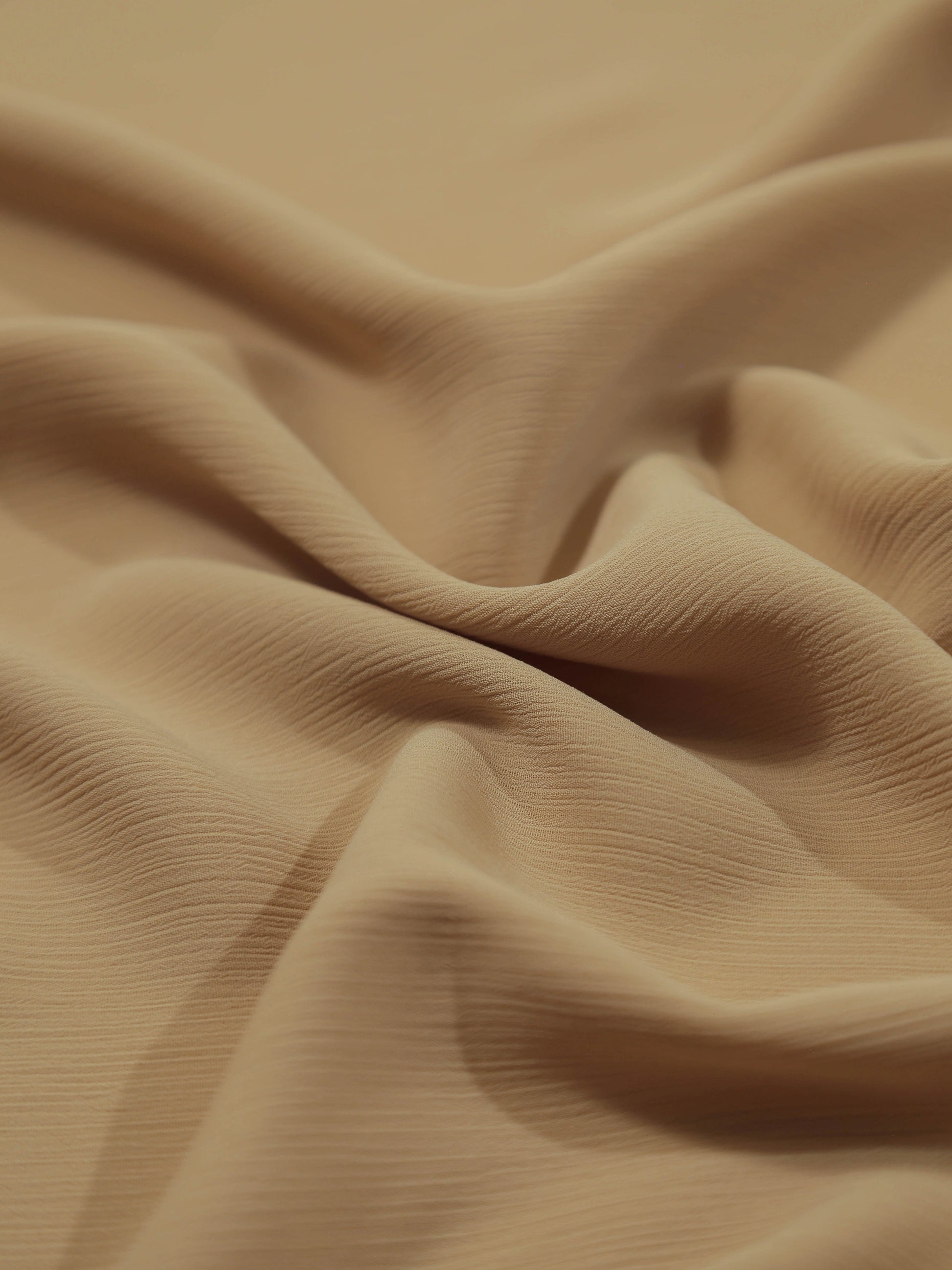 Close-up of soft crinkled fabric in a warm mocha shade, showcasing texture of Crinkle Georgette - Mocha