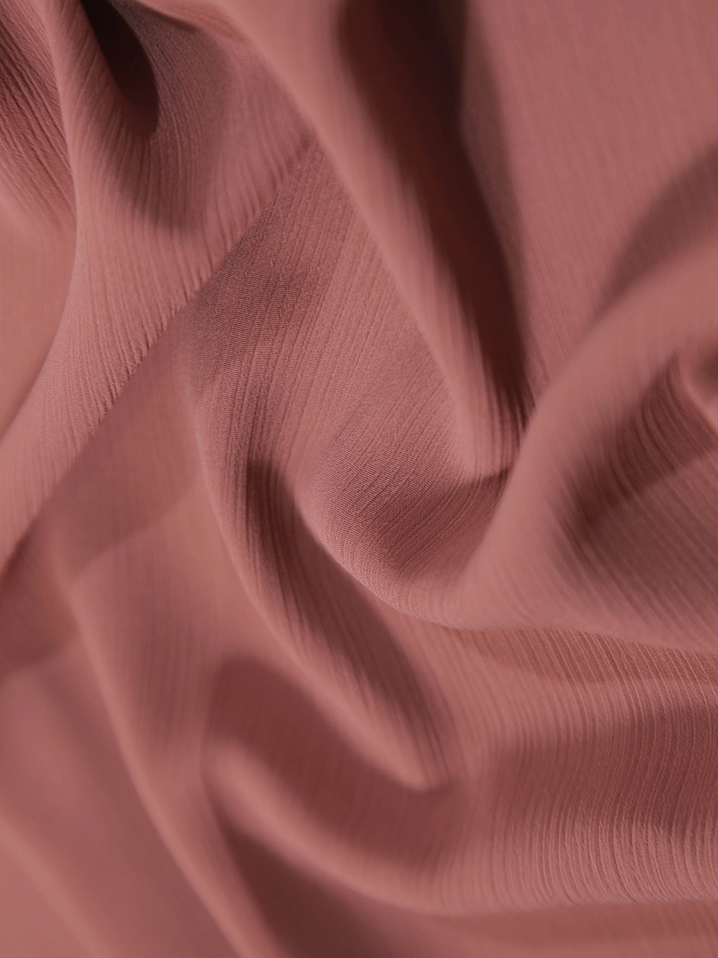 Crinkled soft fabric texture in muted pink shade showcasing Crinkle Georgette - Pink material quality