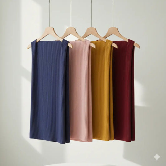 Four hangers with ribbed knit skirts in blue, pink, yellow, and red on a white background.