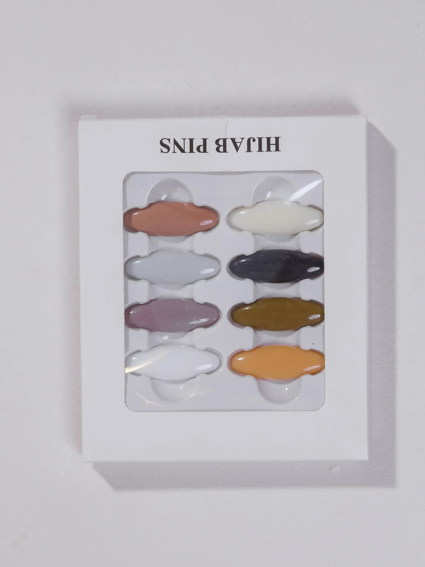 Set of colorful hair pins in a clear plastic window on a white background