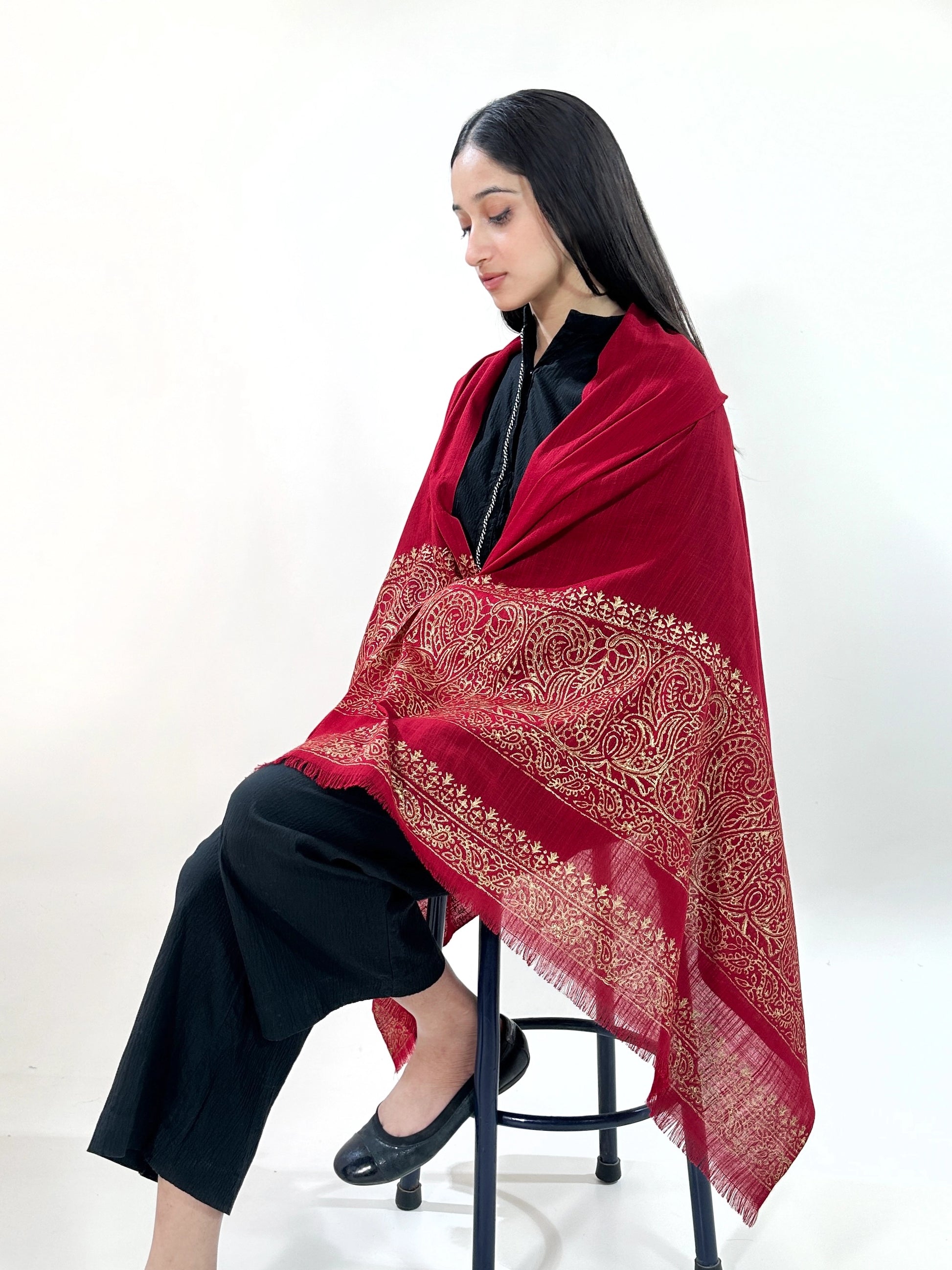 Woman wearing a red patterned shawl on a white background