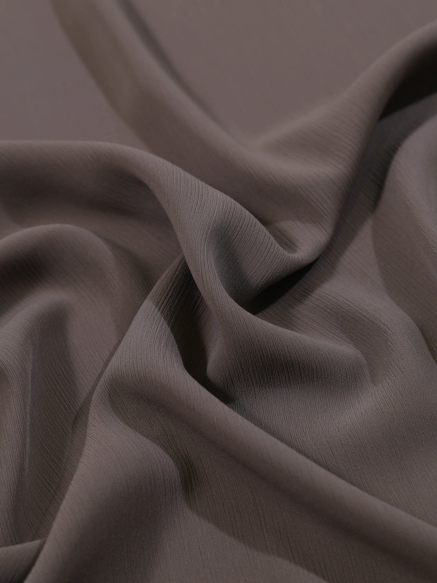 Close-up of dark brown fabric with folds