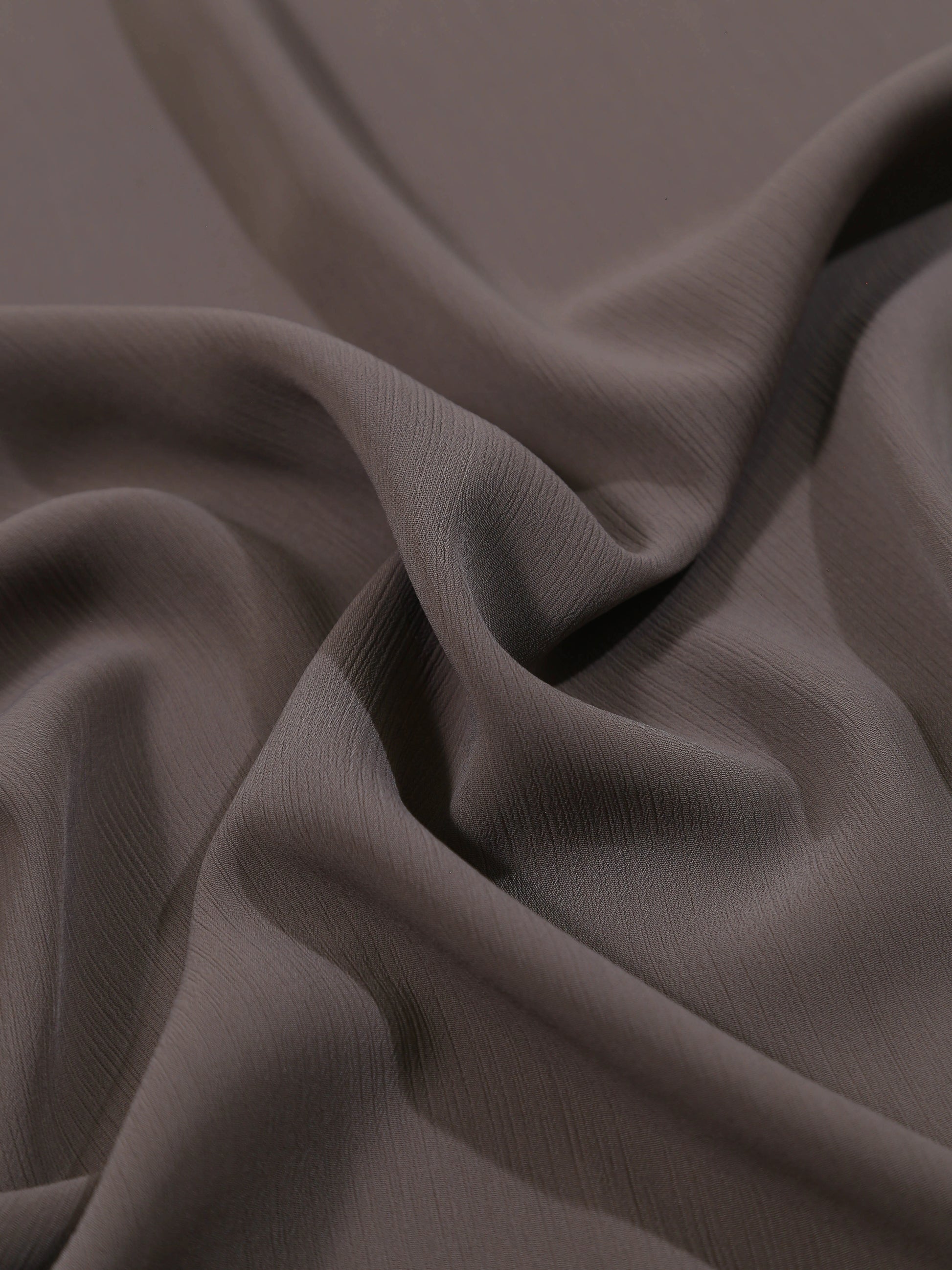 Close-up of dark brown fabric with folds