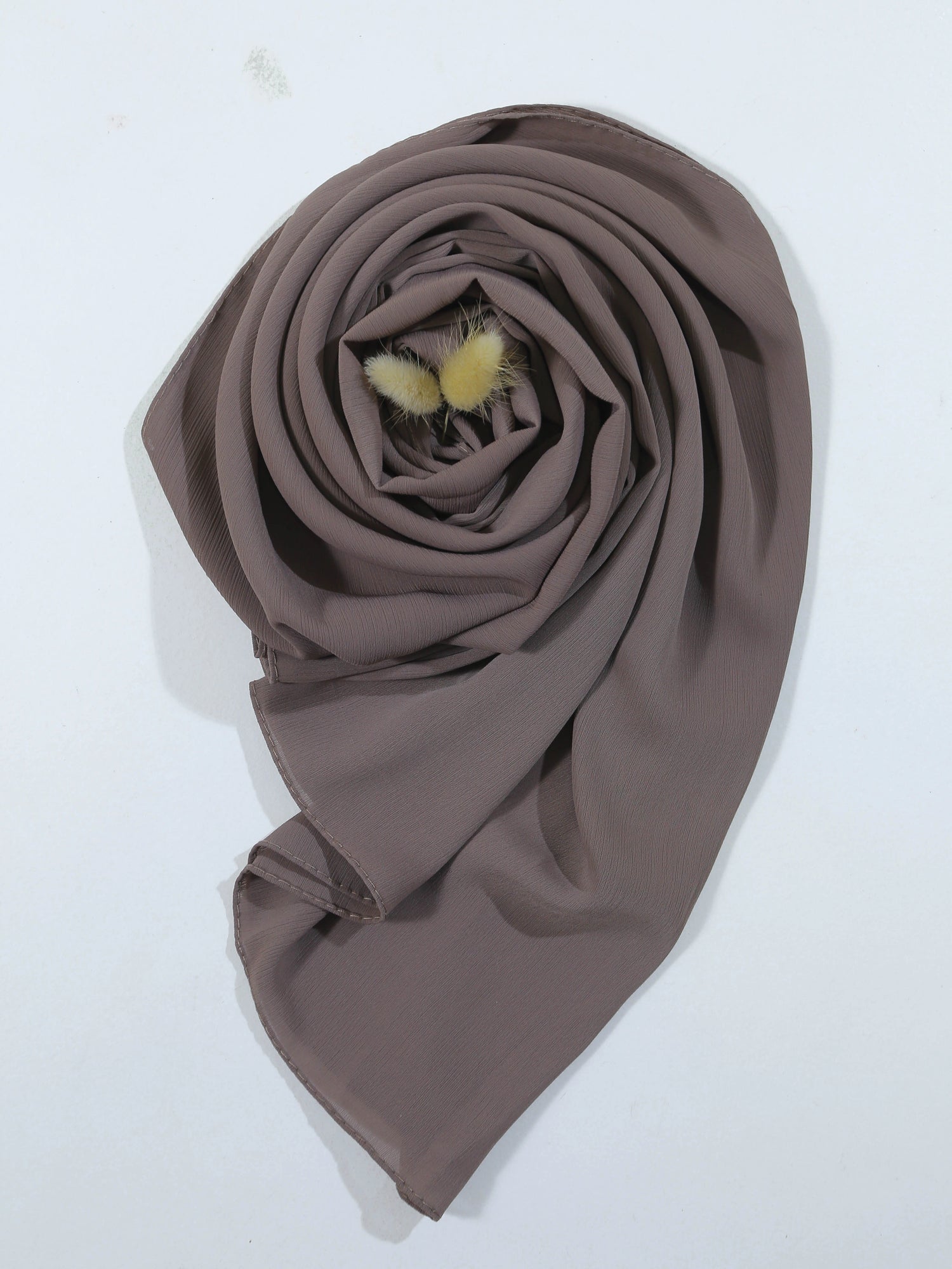 Brown scarf with fluffy pom-poms on a white background