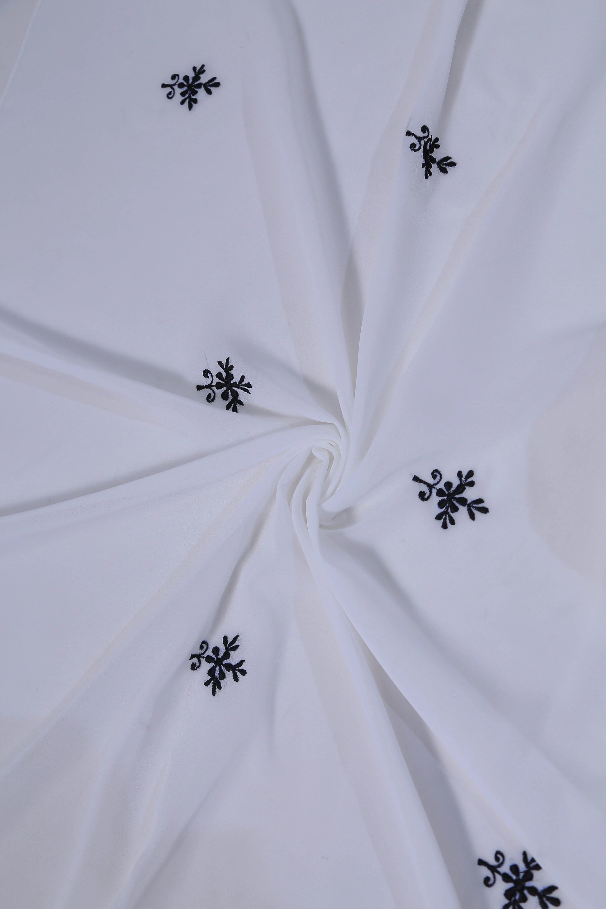 White fabric with black floral embroidery