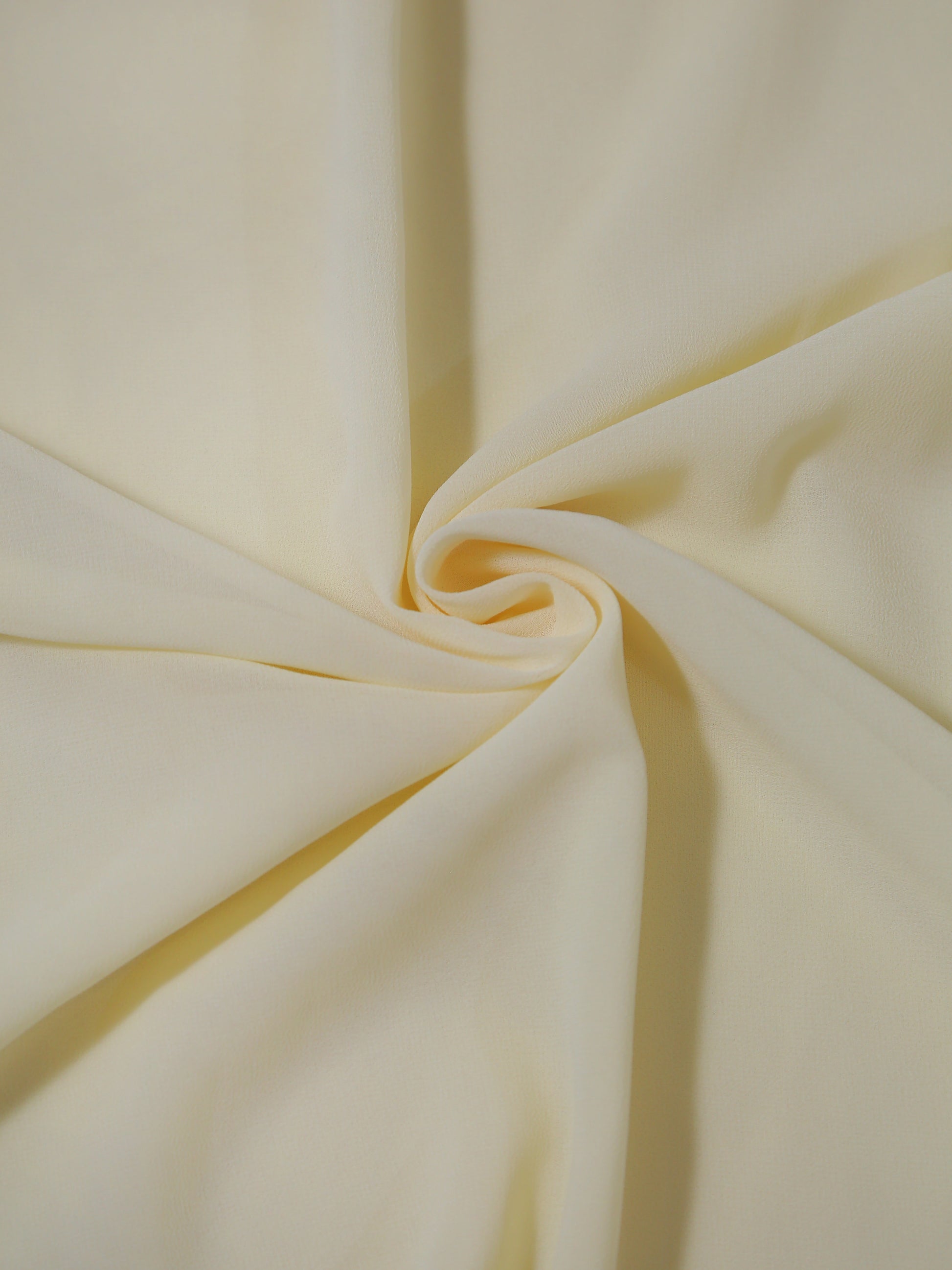 Close-up of light yellow fabric with folds