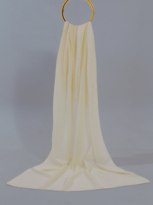 Cream-colored fabric draped over a gold ring on a gray background