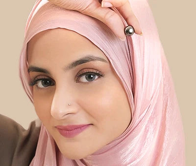 Woman wearing a pink hijab against a beige background