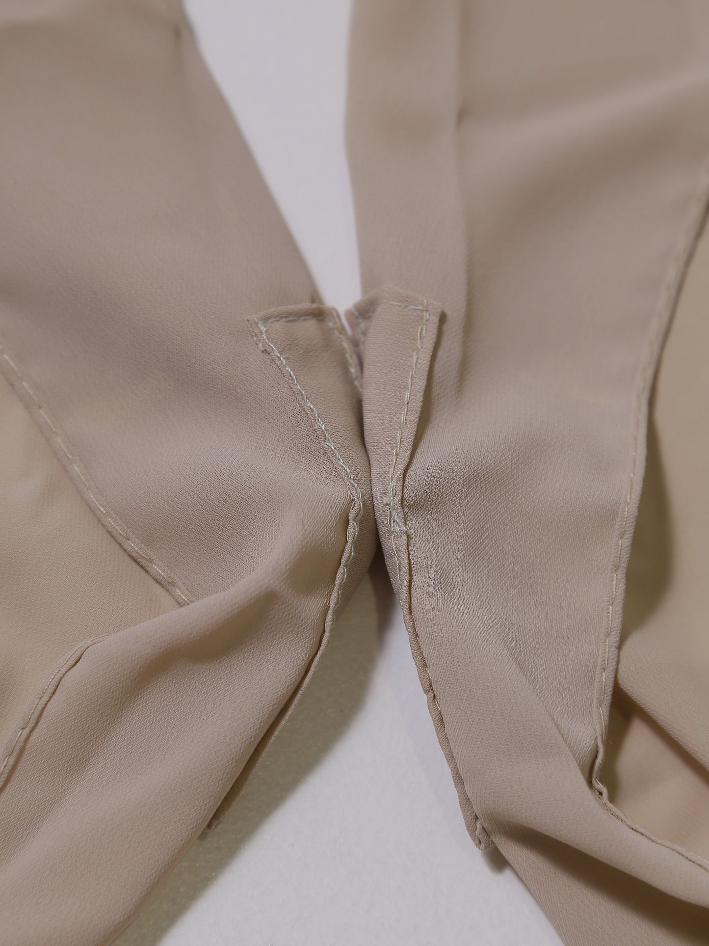 Close-up of beige fabric with a focus on texture and stitching.