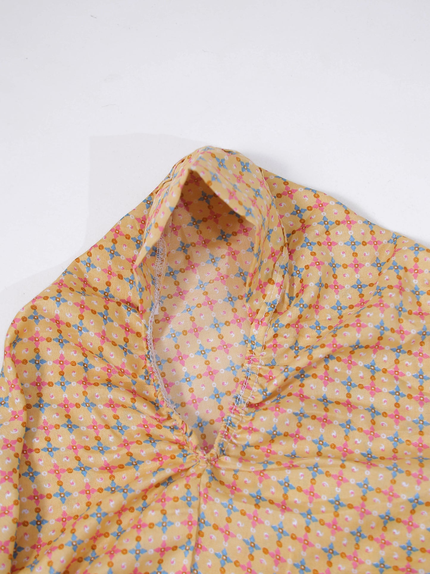 Yellow fabric with a colorful geometric pattern on a white background