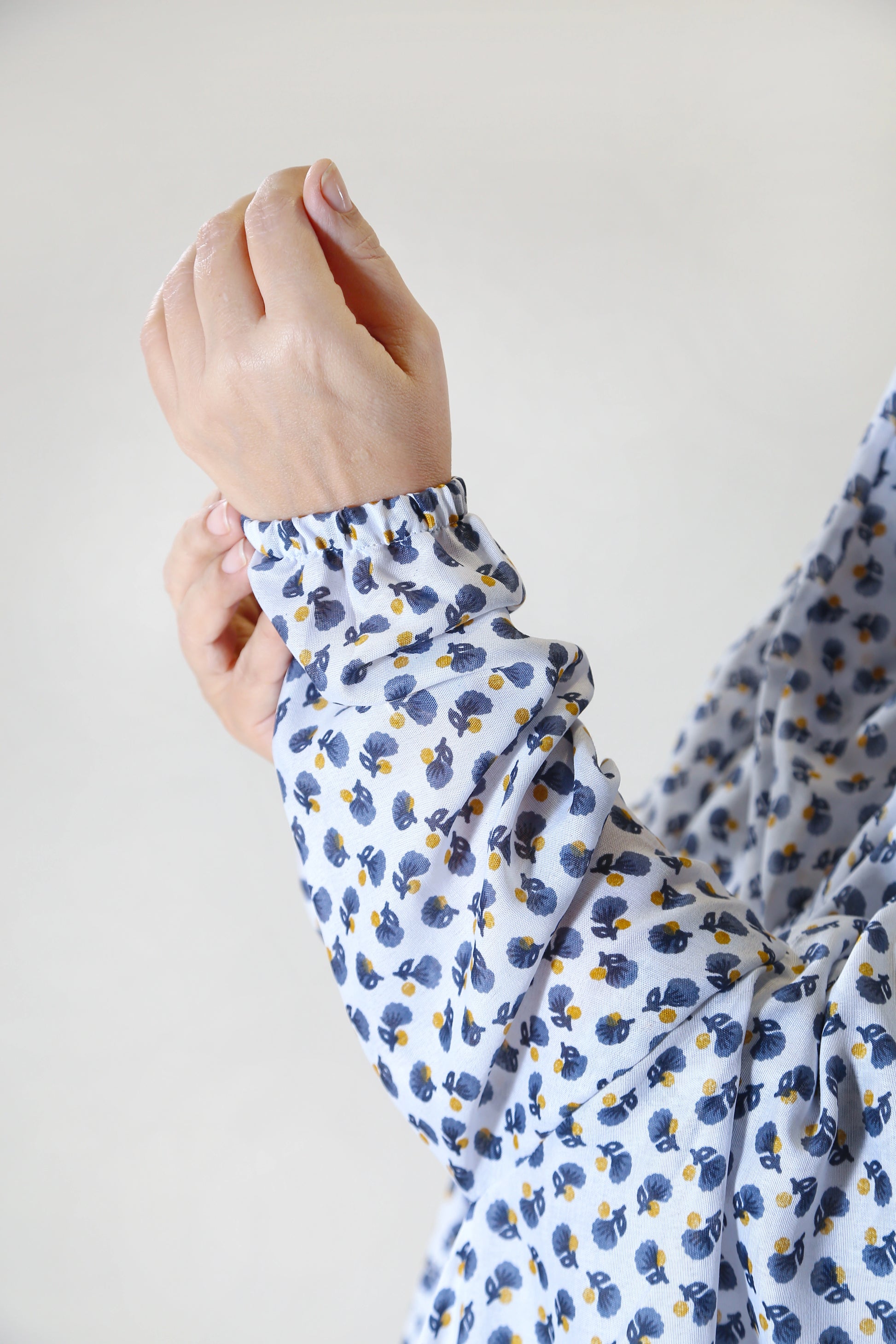 Close-up of a person wearing a floral-patterned shirt with a plain background