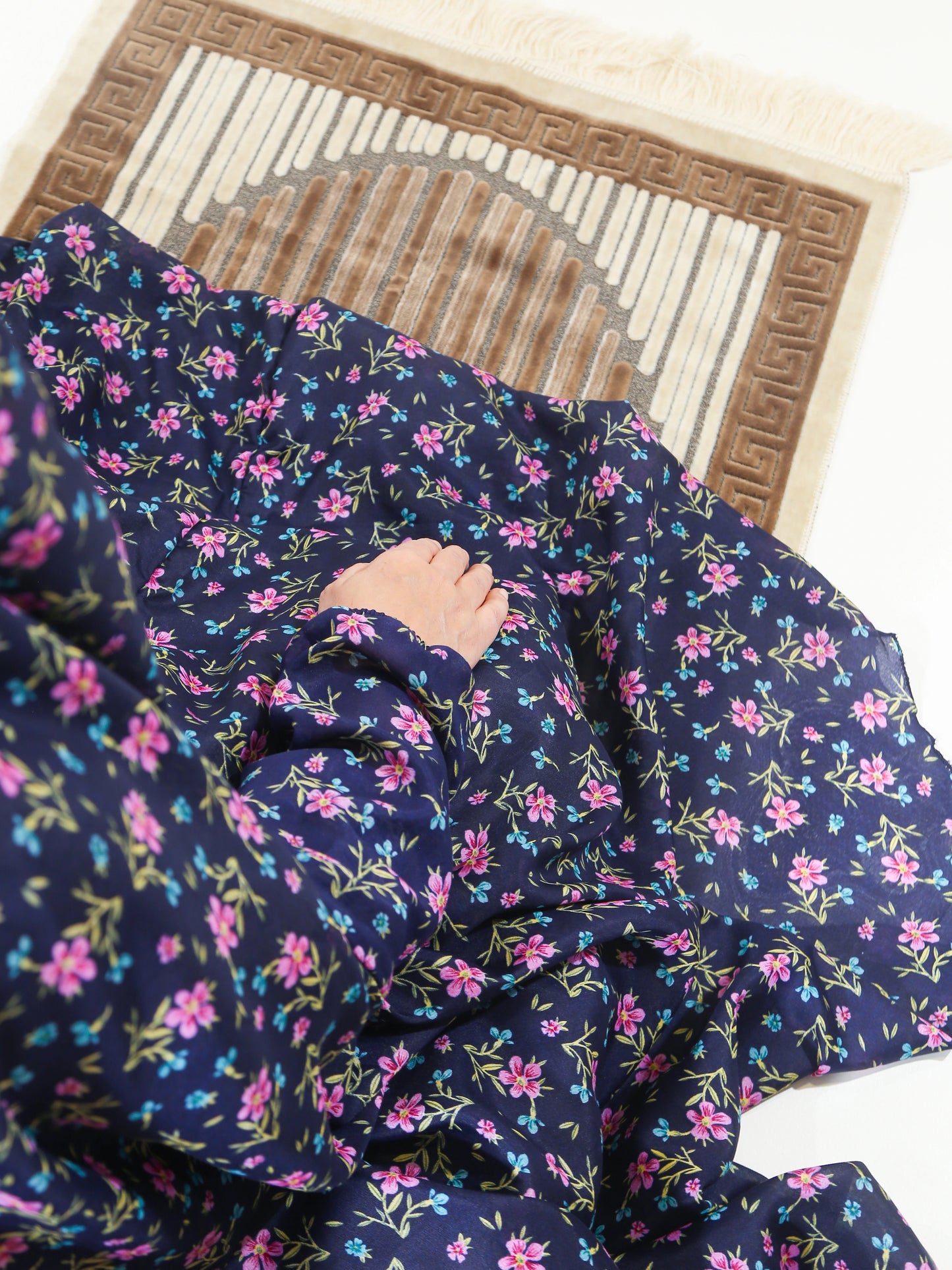 Navy blue fabric with pink floral pattern on a wooden surface