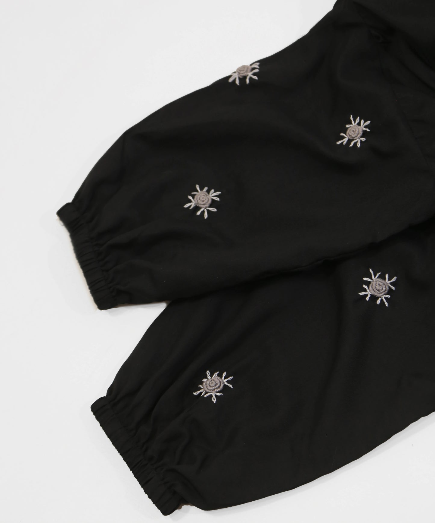 Black namaz chadar with embroidered designs on a white background