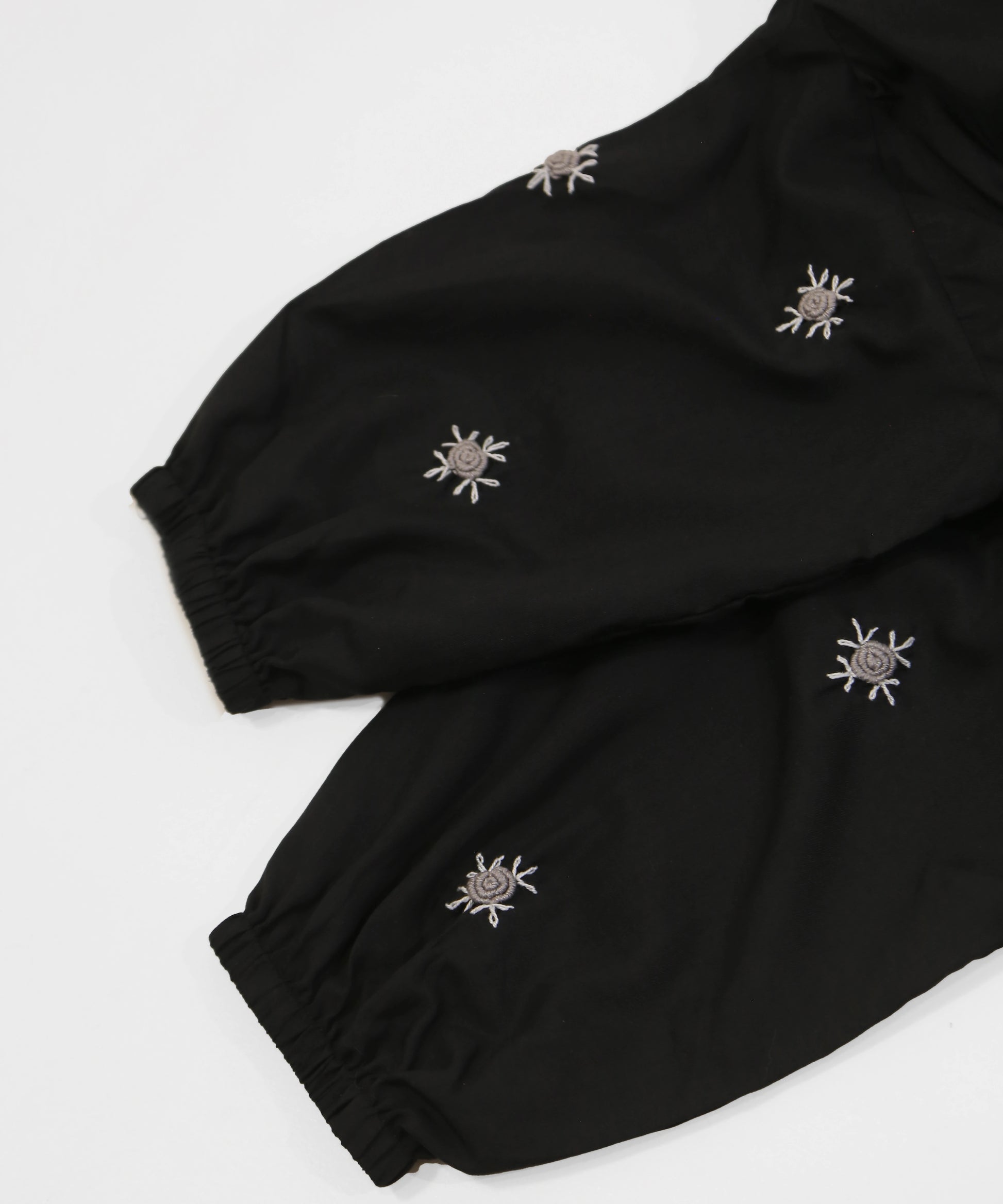 Black namaz chadar with embroidered designs on a white background