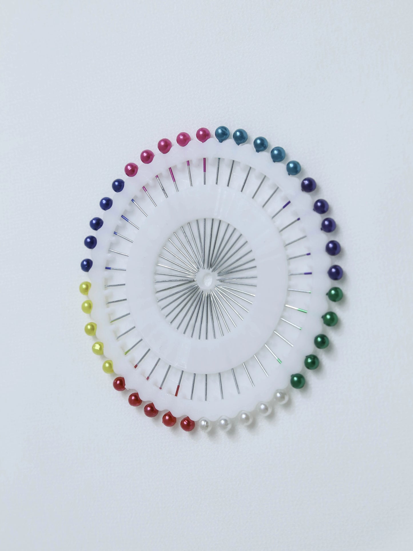 Colorful pins arranged in a circular pattern on a white background