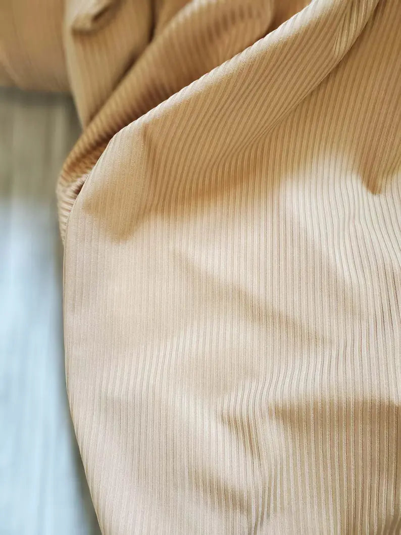 Close-up of beige corduroy fabric with a blurred background