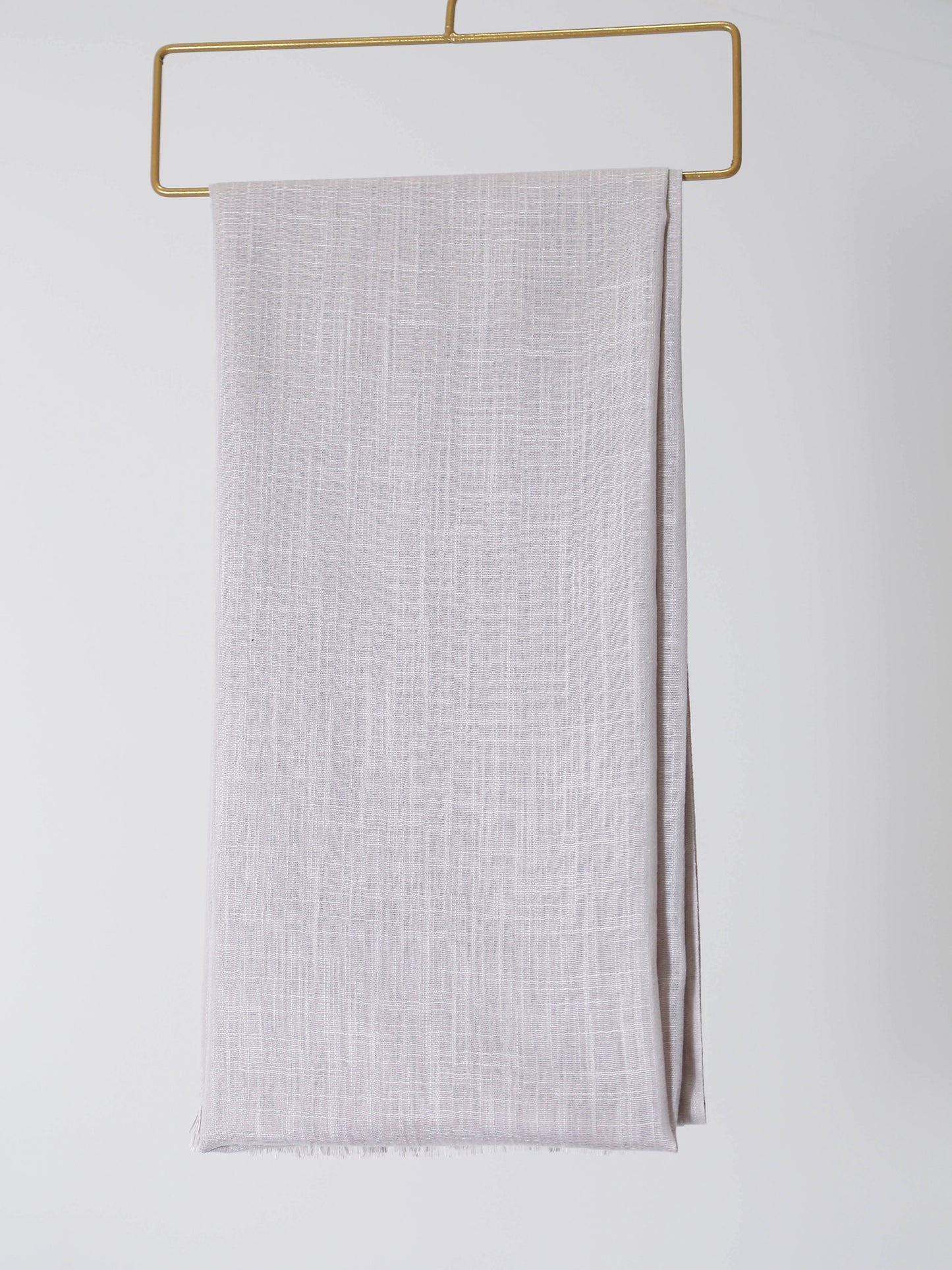 Light gray fabric on a gold hanger against a white background